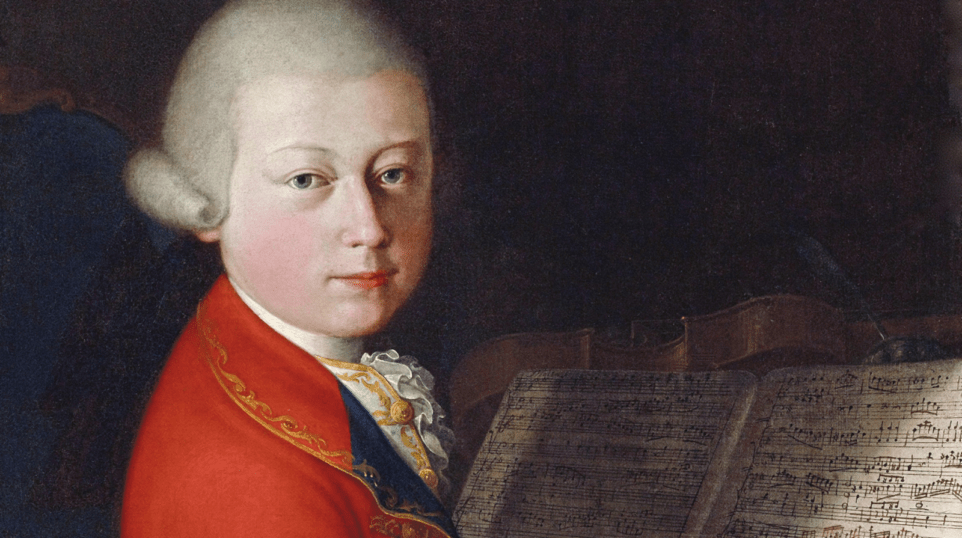 Portrait of Wolfgang Amadeus Mozart aged 13, in white wig, looking over his right shoulder, wearing red coat; music manuscript and string instrument in background.